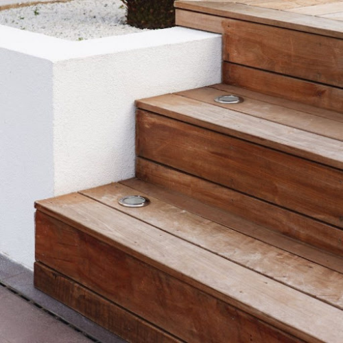 Wooden outdoor stairs featuring recessed ground lights at edges