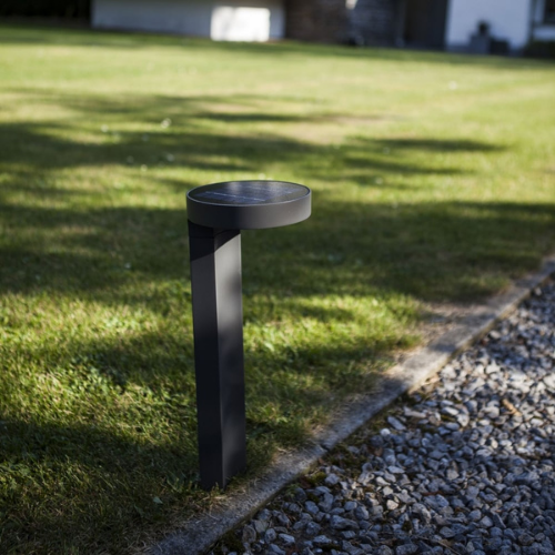Black bollard light, located along garden path