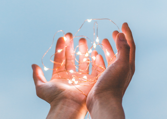 Fairy lights being held in open hands