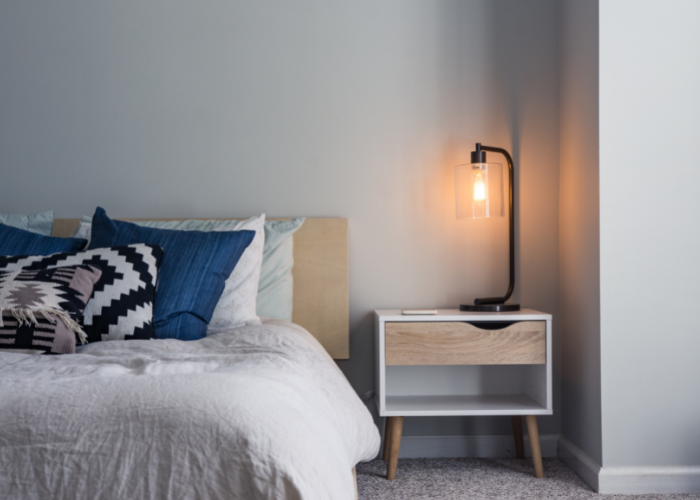 table lamp glowing next to a bed